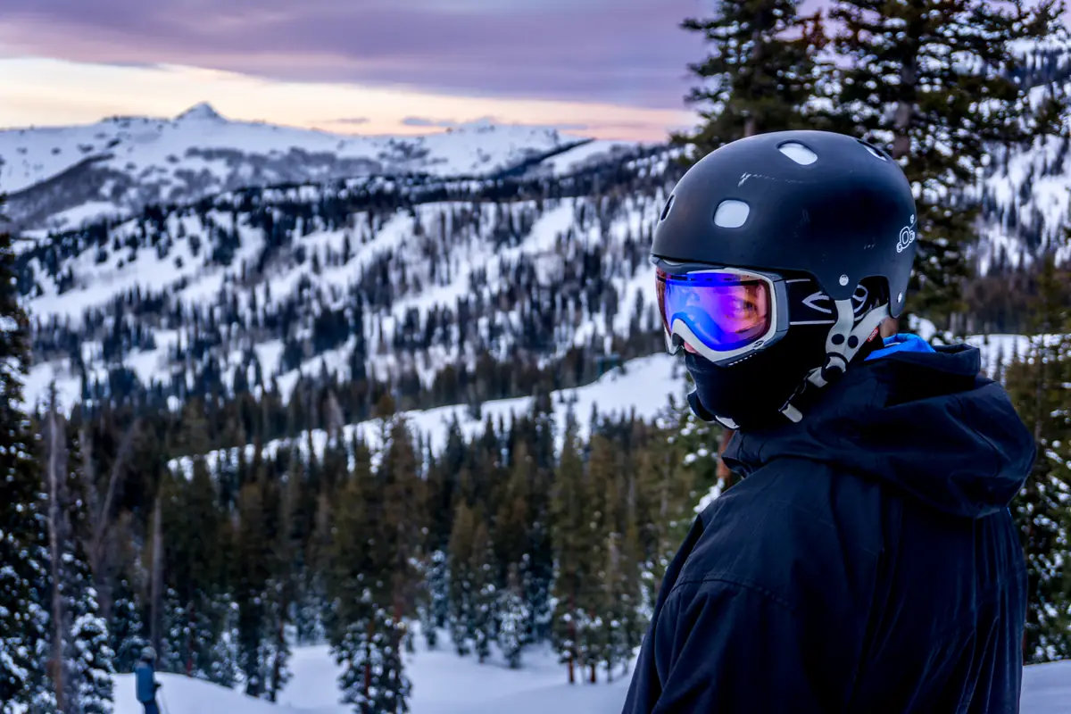 Snowboarder looking out over snowy ridges at Brighton Resort