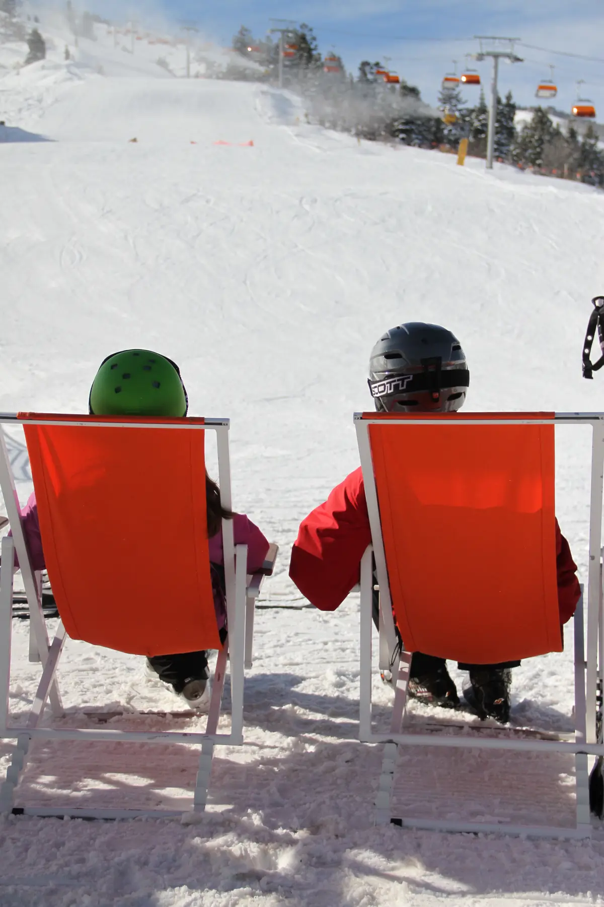 Skiers relaxing in deck chairs at Ski Beach in Canyons Village